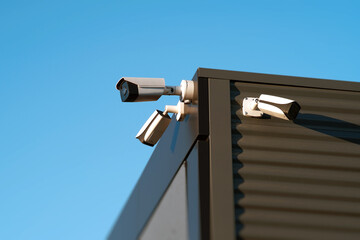 The image provides a closeup view of several security cameras that are installed on the exterior of...