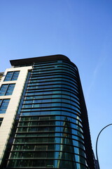 Neubau eines modernen Eckhaus an der Kreuzung M&uuml;nzstra&szlig;e und Max-Beer-Stra&szlig;e vor blauem Himmel im Sonnenschein im Stadtteil Mitte in der Hauptstadt Berlin