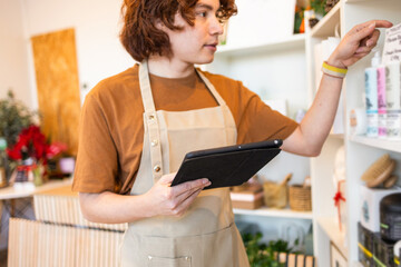Retail worker organizing organic store inventory with a digital tablet