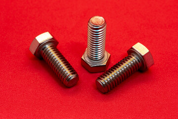 Bolts and nuts on a red background