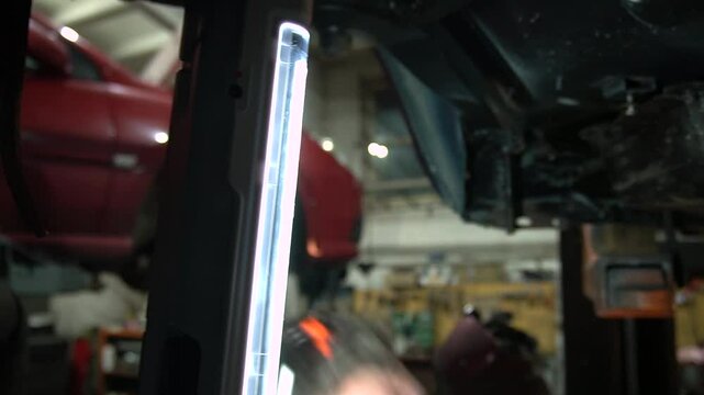 young mechanic repairs and installs an old gray car after a road accident (157)