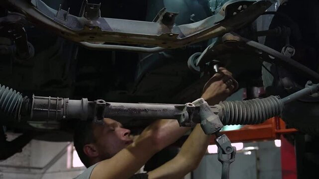 young mechanic repairs and installs an old gray car after a road accident (157)