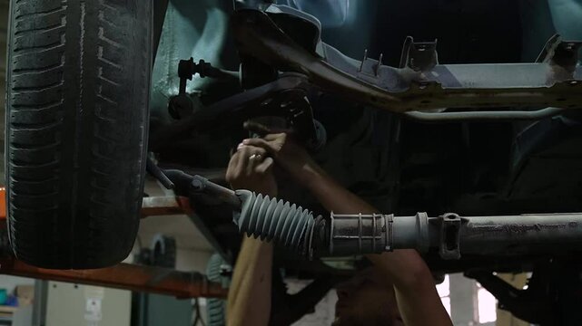 young mechanic repairs and installs an old gray car after a road accident (157)