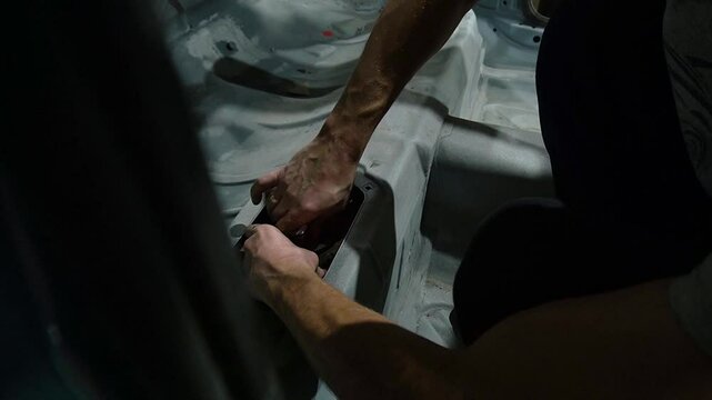 young mechanic repairs and installs an old gray car after a road accident (157)