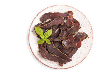 Armenian Basturma dried meat on plate with pepper and herbs isolated on white. Top view.
