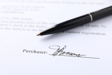Signature and pen on paperwork, closeup view
