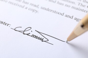 Pen leaving signature on contract, closeup view