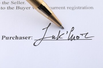 Signature and pen on paperwork, closeup view
