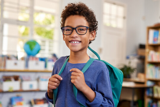 Smiling mixed race boy with eyeglasses at school