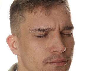 Distressed young man crying on white background