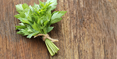 Bunch of lovage herb on wooden background  © vaivirga