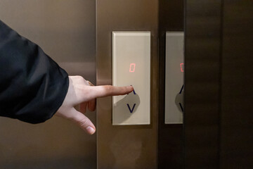 pressing an elevator button with a hand, highlighting interaction with modern technology and...