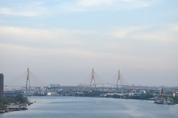 Obraz premium bridge and building cityscape on river in sunset at Thailand