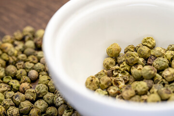 Dry green pepper spice close up. Green peppercorns macro view.
