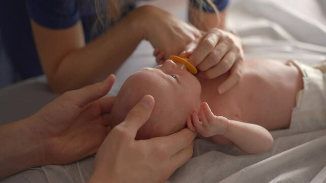 A newborn baby and his mother visit an osteopath for a health checkup and gentle therapy to address any potential issues. A caring moment focused on the baby's health, wellbeing, and early development