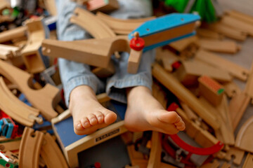 Child, cute boy, playing with toys in a playroom, focus on his feet
