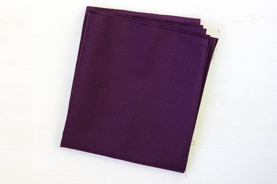 Dark violet unstitched cotton fabric isolated on a white background. This versatile fabric is suitable for crafting women's blouses, petticoats, salwars, kameezes, and more. Top view.