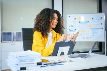 A cute African American businessman works diligently at his office desk, managing accounting tasks,...