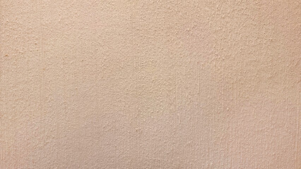 close-up view of a light beige wall with a subtle, fine-grained texture, creating a warm and inviting. brown backdrop with a slightly rough, almost sandy feel.