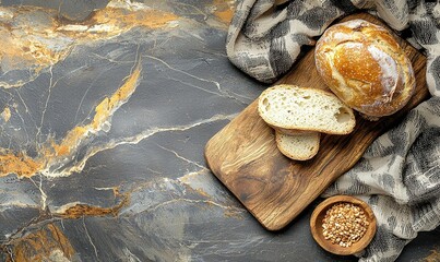 Freshly baked bread sliced on wooden board, dark marble background, baking concept