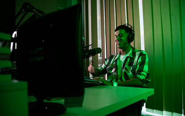 Portrait of young male podcaster making podcast from his home studio.