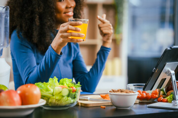 African American woman sitting  table, enjoying a colorful salad orange juice, highlighting the health benefits of five-color fruits vegetables, rich in antioxidants, reducing cancer risks,wellness