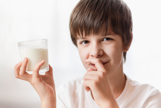 Handsome boy holding a glass of milk in his hand