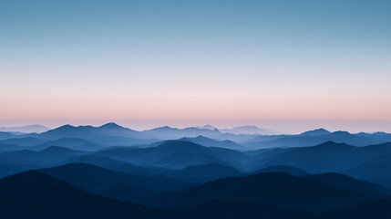 Fototapeta premium Scenic view of layered mountain ranges at twilight with a pastel sky
