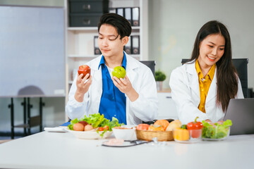 Two nutritionists,female and male, work in a hospital, analyzing vegetable and fruit salads, offering online advice, helping patients embrace clean eating habits and weight control for better health