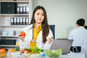 Two nutritionists,female and male, work in a hospital, analyzing vegetable and fruit salads,...