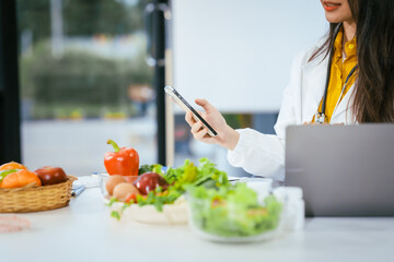 Two nutritionists,female and male, work in a hospital, analyzing vegetable and fruit salads,...