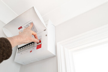 Electrician seen about to switch off the Main Switch for electricity into a typical house. Circuit...