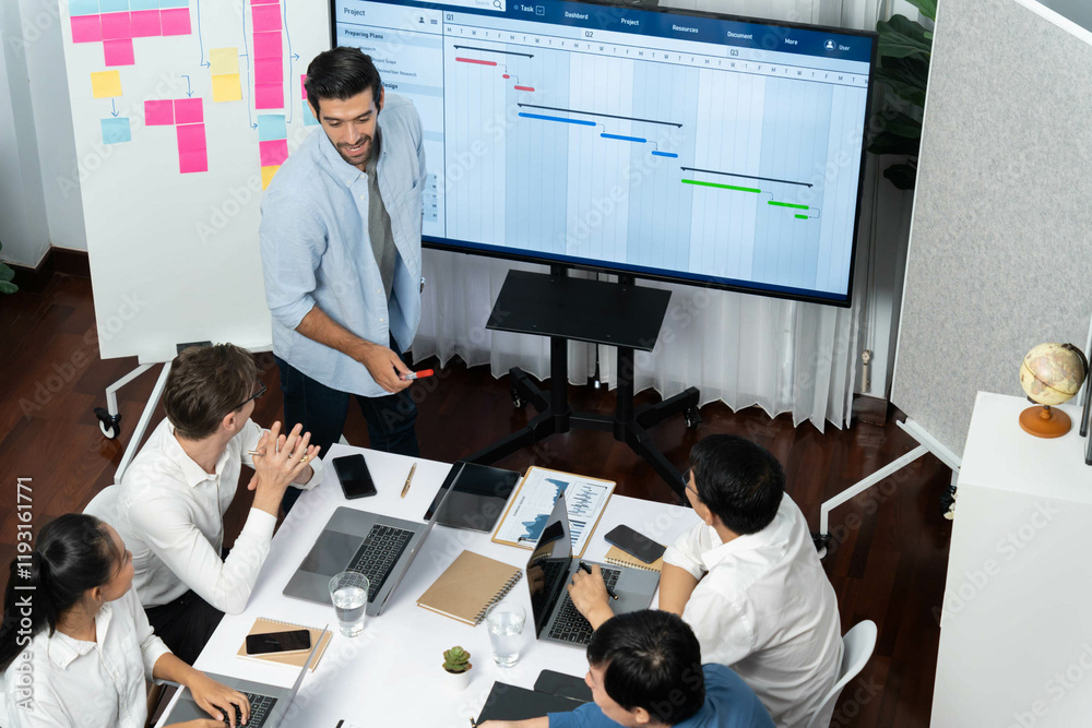 Leinwandbilder Project manager communicate and collaborate with team using project management software display on monitor, tracking progress of project task and making schedule plan at meeting table. Prudent