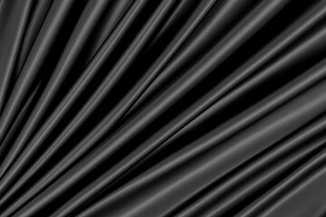 Fototapeta premium Luxurious black silk fabric showcasing smooth, flowing textures and elegant folds for artistic backgrounds and designs.