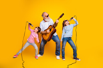 Happy family bonding with music on yellow backdrop showcasing joy and togetherness