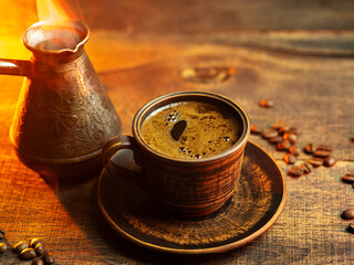 cup of Turkish coffee and cezve on a wooden table