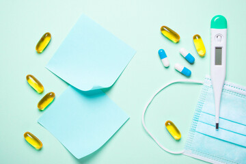 Pills, Sticky Notes, and Electronic Thermometer on Light Background