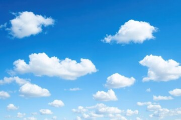 Obraz premium Bright and fluffy white clouds scattered across a clear blue sky, perfect for conveying a sense of tranquility and openness.