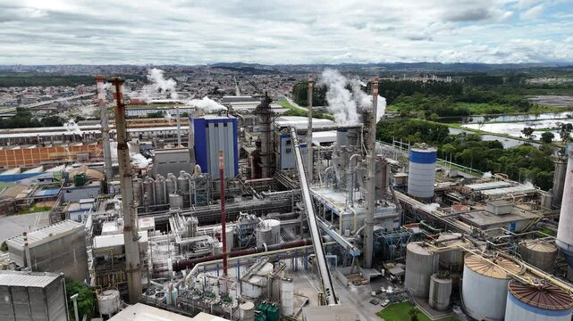 V&iacute;deo 4K a&eacute;reo de drone mostrando uma ind&uacute;stria de papel e celulose. Chamin&eacute;s, caldeiras e vapores evidenciam o processo industrial e a produ&ccedil;&atilde;o sustent&aacute;vel de papel