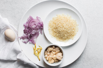 Overhead view of ingredients for making rice chicken congee, mise en place of ingredients for making rice and chicken porridge, ingredients for chinese chicken congee, korean dak juk or japanese okayu