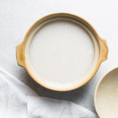 Overhead view of Plain rice congee in a clay pot, top view of rice porridge, chinese congee, korean juk or japanese okayu in a claypot