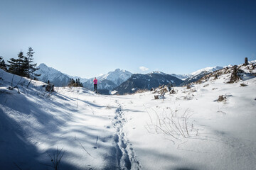 Obraz premium Ein Wanderer blickt vom Winterwanderweg in die verschneiten Berge des Zillertal