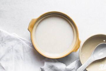 Overhead view of Plain rice congee in a clay pot, top view of rice porridge, chinese congee, korean juk or japanese okayu in a claypot