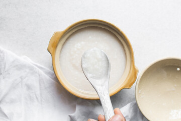 Overhead view of Plain rice congee in a clay pot, top view of rice porridge, chinese congee, korean juk or japanese okayu in a claypot