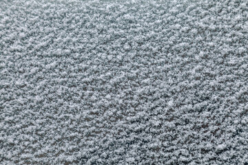 snow on car glass close up as background