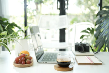 laptop and coffee cup with notebook and plants pot and orange on white table work from home