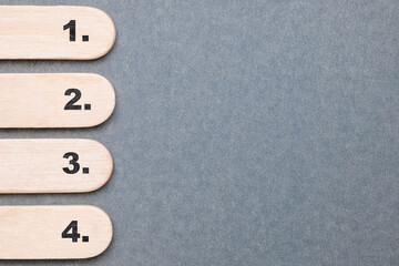 One, Two, Three, and Four step, text on the flat wood sticks on gray paper