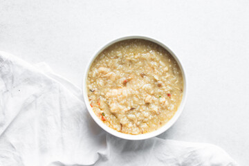 Overhead view of rice chicken congee, top view of rice and chicken porridge, chinese chicken congee, korean dak juk or japanese okayu