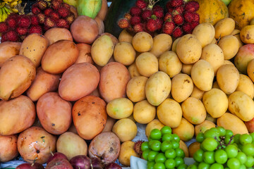 Lots of different ripe fruits on the market in Asia. Fruity multicolored background.