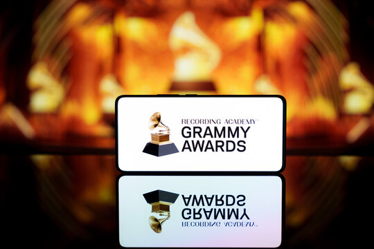 A smartphone displaying the Grammy Awards logo against a blurred awards ceremony background.